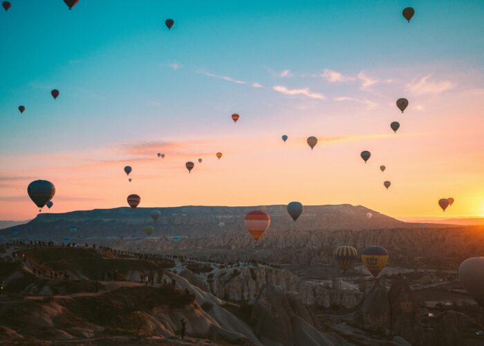 Colorful hot air balloons soaring over Cappadocia at sunrise, Turkey.